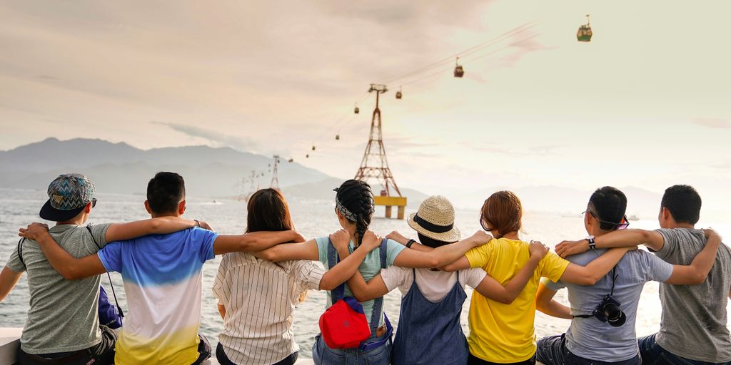 people holding shoulders sitting on wall